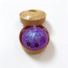 A purple unicorn dumpling squishy stress ball is shown inside its bamboo steamer box.