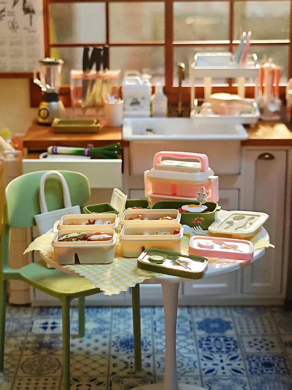 A miniature doll picnic lunch box with a handle is displayed on a table in front of a kitchen window.
