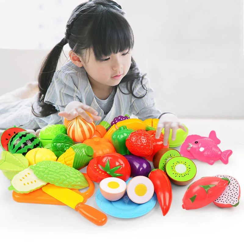 A child is using a colorful pretend play kitchen set with plastic fruits and vegetables for imaginative play.