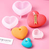 A set of pink and orange silicone heart candle molds for DIY crafting displayed on a pink background.