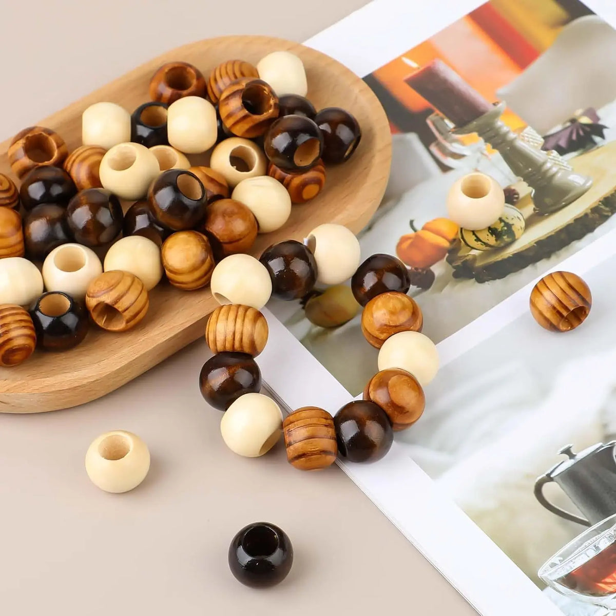 A collection of natural wooden spacer beads in various shades and sizes arranged on a wooden board and string.