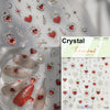 Close-up of Tomoni nail art stickers featuring red and gold heart designs, stars, and decorative elements on a clear backgrou