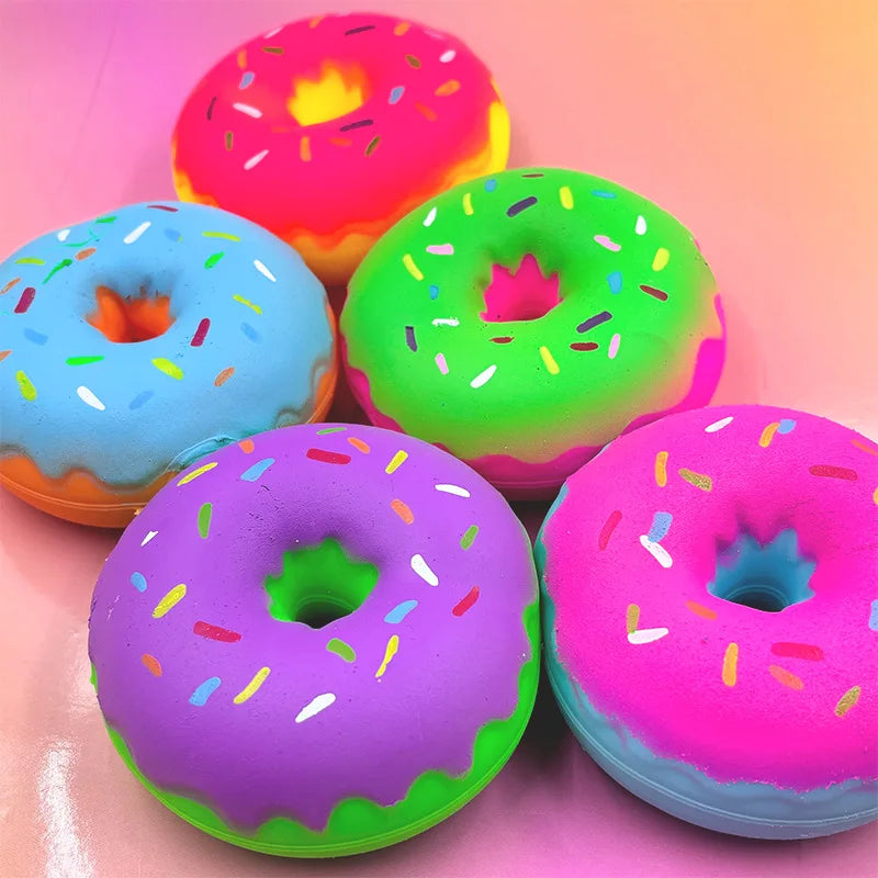 A collection of brightly colored, squishy cartoon donuts in pink, green, and purple for sensory play.