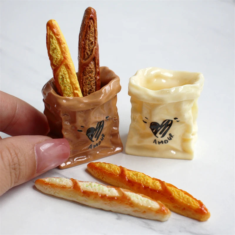 A miniature dollhouse set featuring a basket made of brown clay holding a baguette and another baguette.