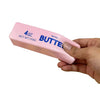 A hand holds a pink butter stick fidget toy labeled 4oz net wt 113g salted butter.