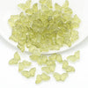 A pile of light green glass butterfly beads for jewelry making