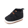 Black baby first walker shoes with a white sole and brown accents