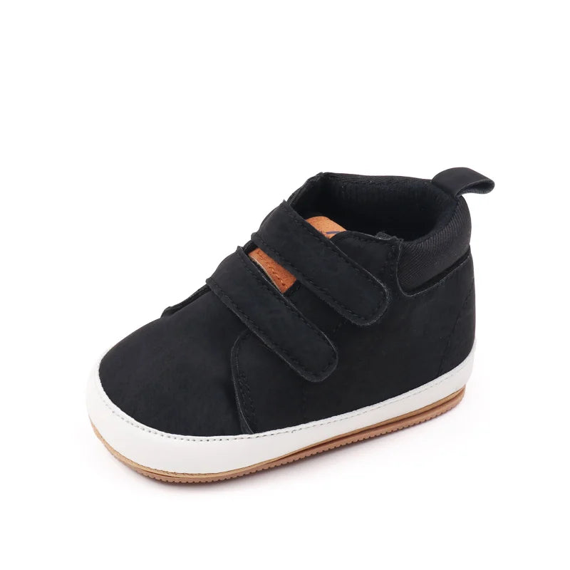 Black baby first walker shoes with a white sole and brown accents