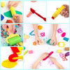 A collection of colorful play dough tools including extruders, cutters, and rollers used by children.