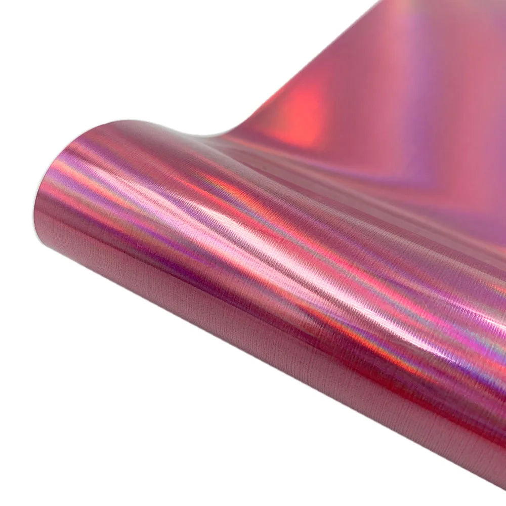 Roll of holographic pink glitter heat transfer vinyl showing iridescent colors and a smooth texture.