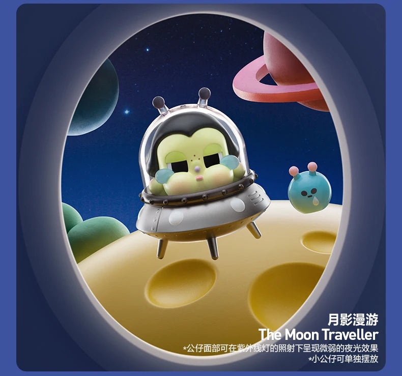 A collectible figurine of a crying baby in a silver helmet floating in space against a dark blue and purple starry background