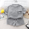 A gray boys' summer cotton t-shirt and shorts set laid out on a white grid background.