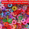 A pile of multiple colors of wave-patterned acrylic beads for jewelry making.