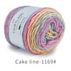 Spool of Fairyland long distance cake ba yarn showing a gradient rainbow color blend.