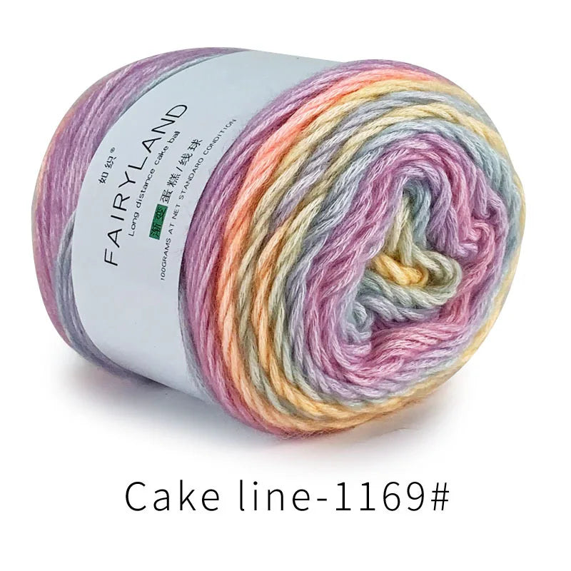 Spool of Fairyland long distance cake ba yarn showing a gradient rainbow color blend.