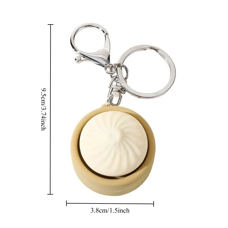 A small, round, beige steamed bun fidget toy attached to a silver keychain ring.