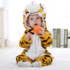 A baby wearing an adorable animal hooded romper with yellow and black stripes, sitting on a white surface.