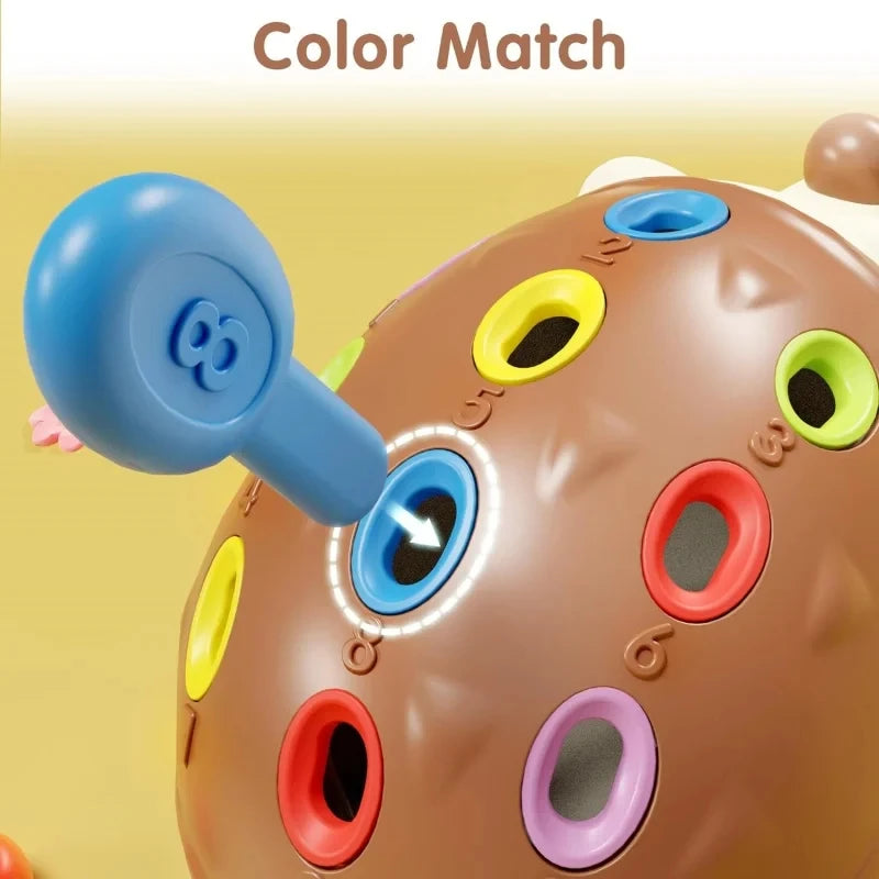 Nahaufnahme eines braunen sensorischen Igelspielzeugs mit verschiedenen farbigen Löchern und einem blauen Fingerteil.