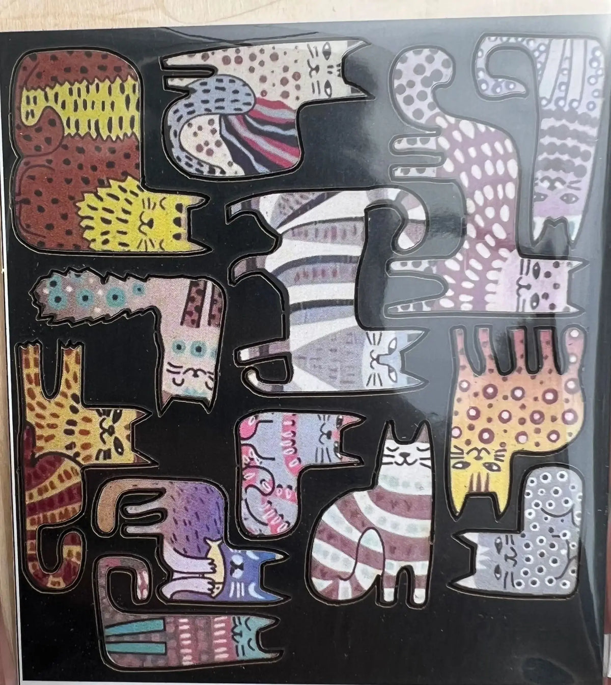 A collection of wooden cat-shaped puzzles featuring various patterns and colors.