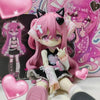 A pink anime-style vinyl art figure with black cat ears and pink hair is displayed in a box featuring pink and purple designs