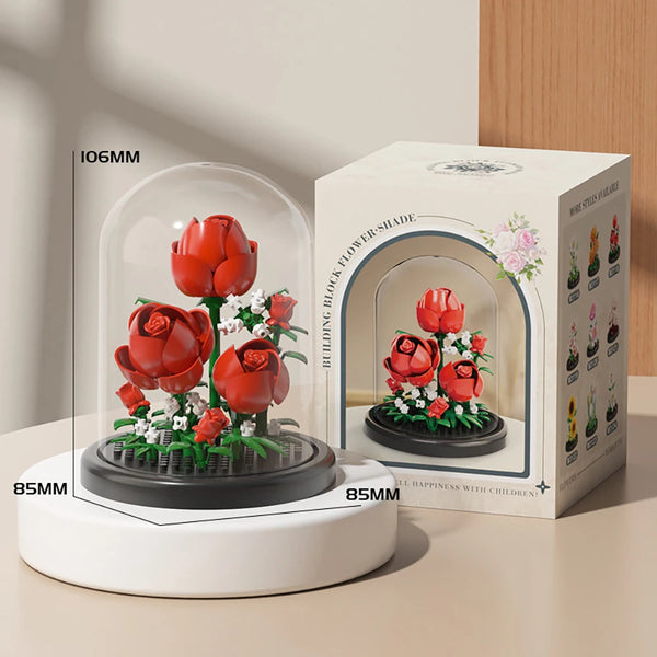A white electric flower-shade device with a red rose arrangement, shown next to its packaging box.