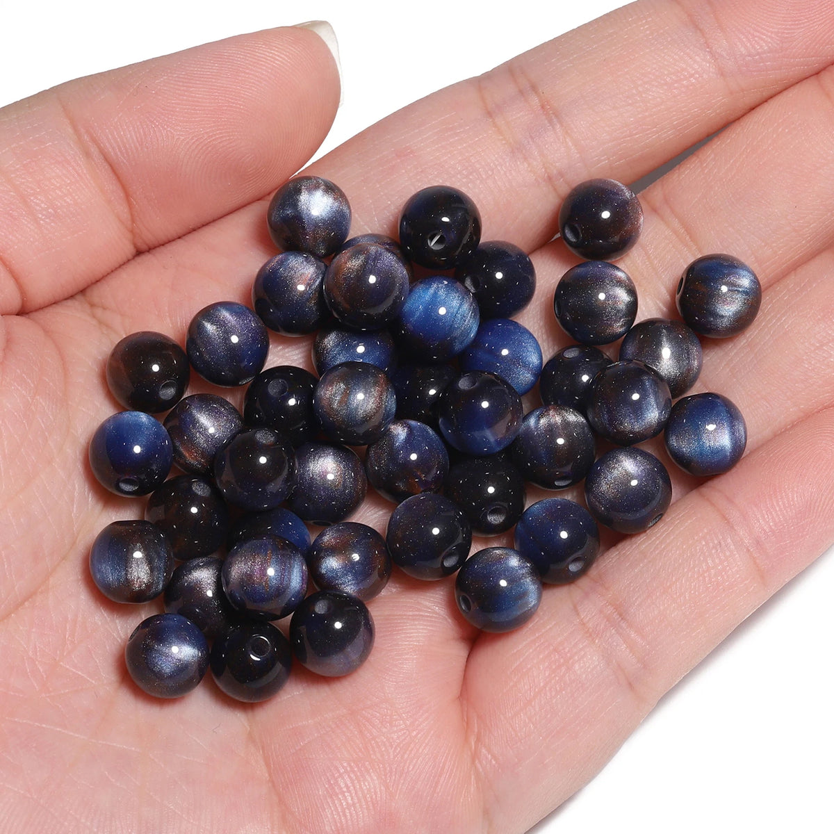 A handful of dark blue and black tiger eye resin beads for jewelry making