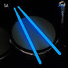 Glow-in-the-dark nylon drumsticks shown crossing over a dark surface.