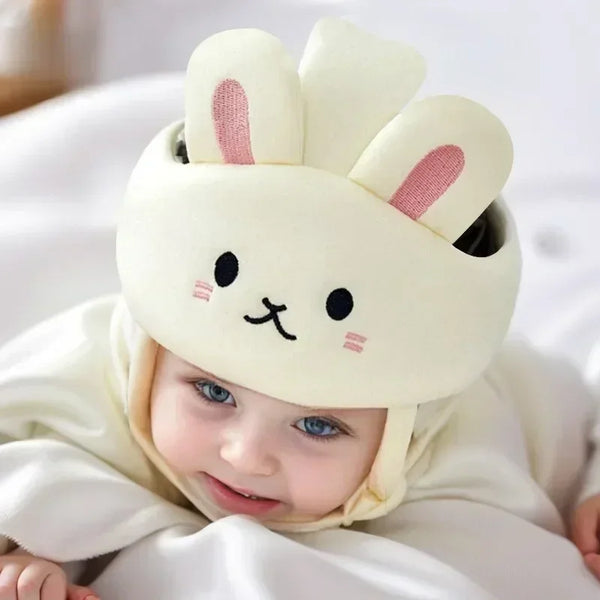 A baby wearing a beige bunny-eared safety helmet and head cushion while lying down.