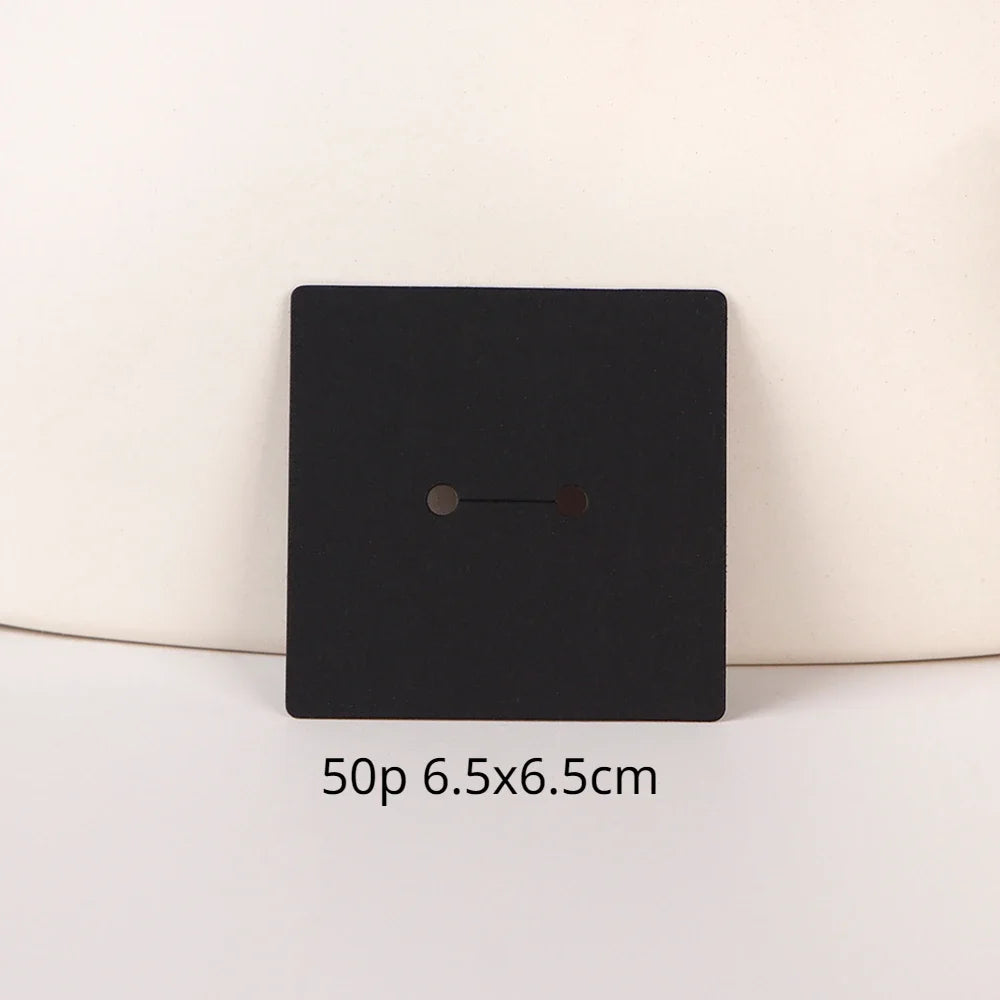 A black square jewelry display card with a small horizontal slot is shown against a light background.