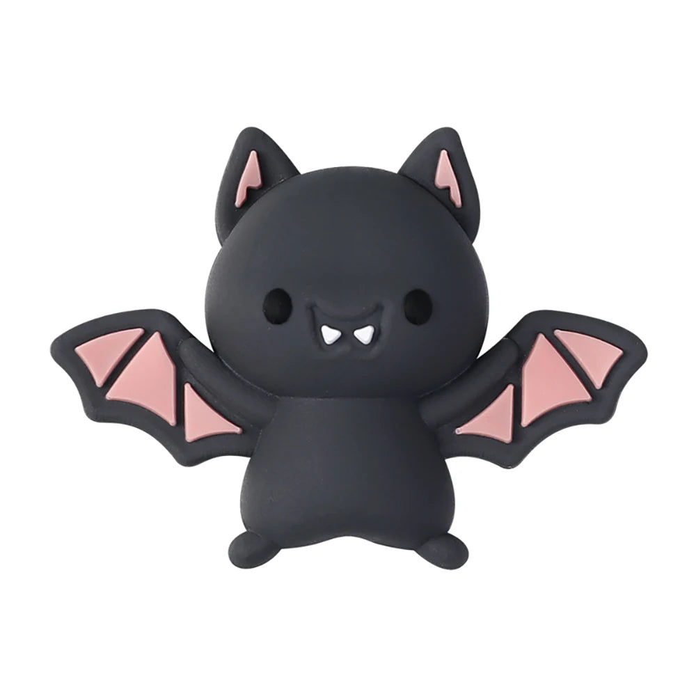 A black silicone bead shaped like a bat with pink accents, used for jewelry making.
