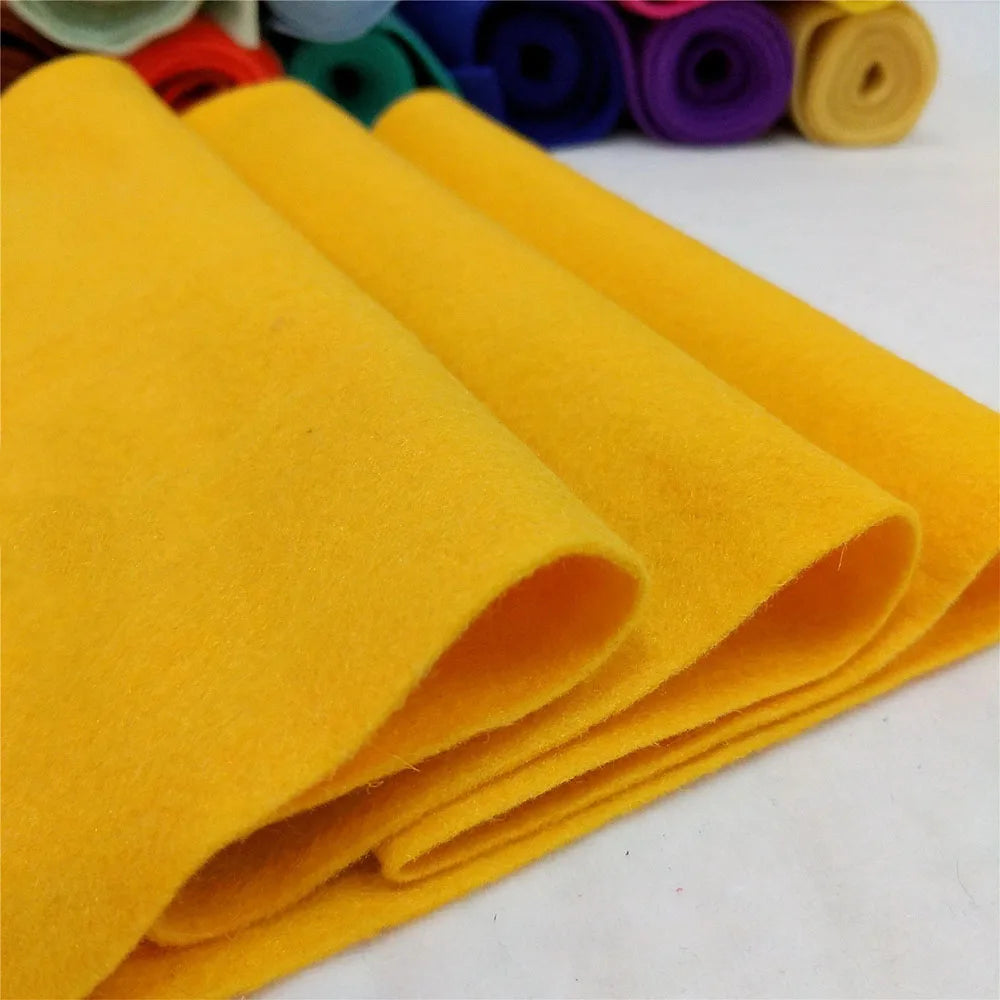 A stack of bright yellow felt fabric sheets rolled up for DIY crafts and sewing projects.