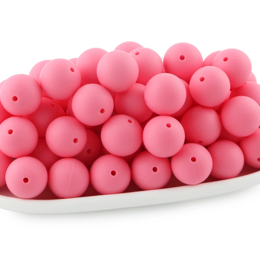 A pile of bright pink round silicone beads for jewelry making and DIY crafts.