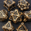 A collection of antique gold-toned metal dice, including a d10 and d12, set against a dark background.