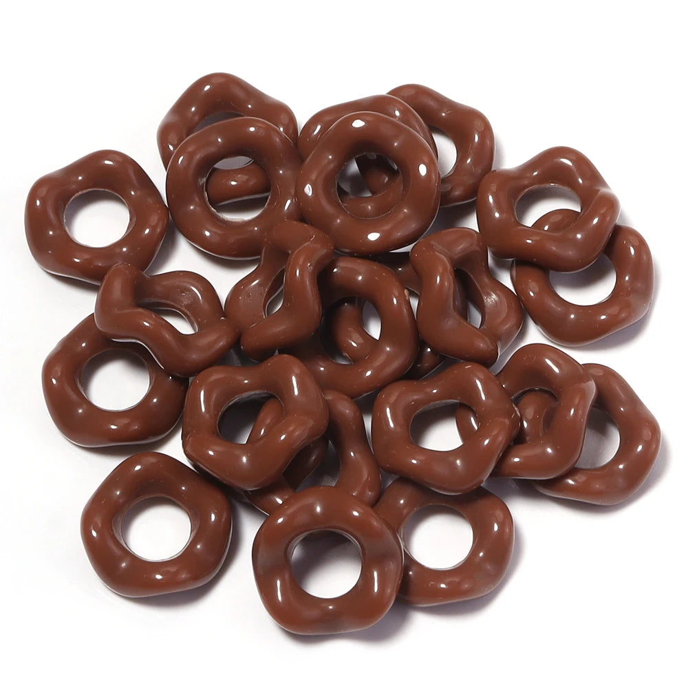 A pile of brown, donut-shaped acrylic spacer beads for jewelry making.