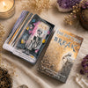 A deck of Pattern Break oracle cards lying on a beige fabric next to dried flowers and crystals.