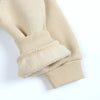 A close-up of a beige knit sleeve and cuff from a kids' multicolor pullover hoodie.
