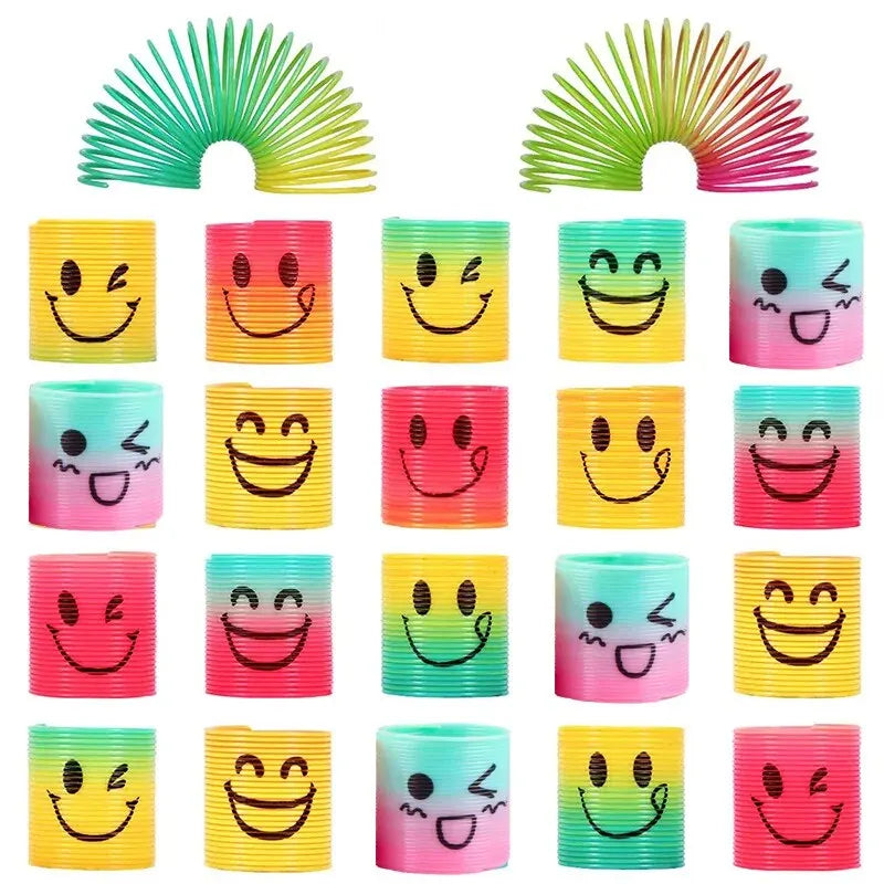 A set of twelve colorful stacking circles or play pieces in various shades of yellow, green, pink, and purple with smiley fac