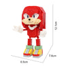 A red dinosaur building block figure with a smiling face and small arms, shown against a white background.