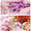 Close-up of a diamond painting kit showing pink and purple floral designs using round and square drills.