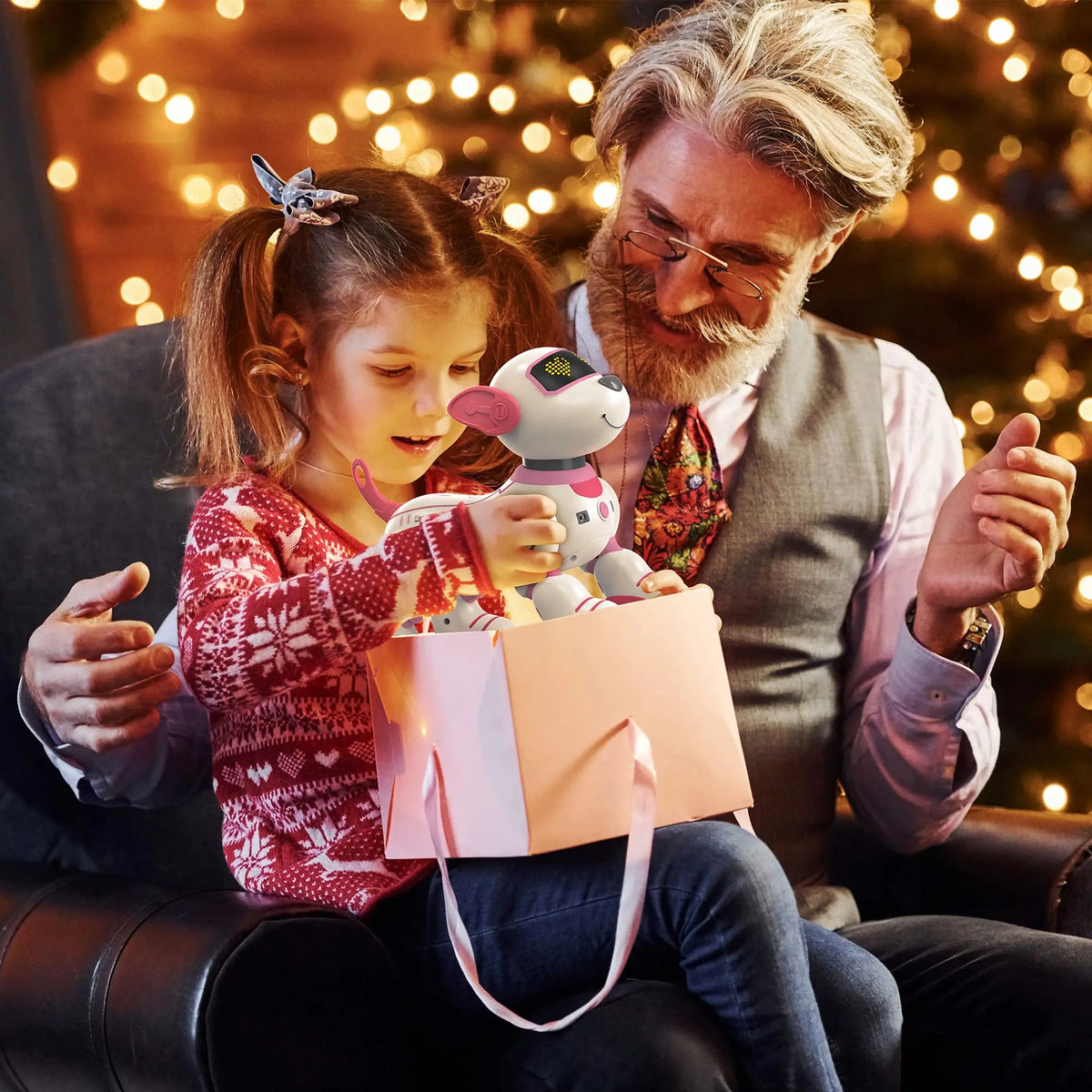 Une jeune fille tient un jouet d'animal robot interactif dans un sac cadeau rose, regardé par un homme.