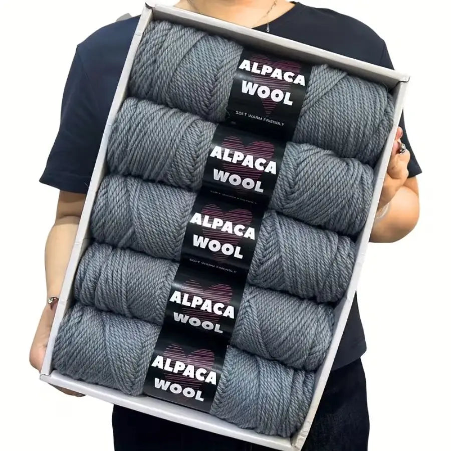 A pack of five balls of gray alpaca wool yarn for knitting and crochet.