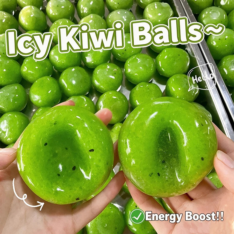 A hand holds a bright green icy kiwi ball stress ball with black spots against a background of many similar balls.