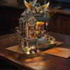 A detailed wooden miniature kit of an illuminated owl post office with furniture, presented on a dark surface.