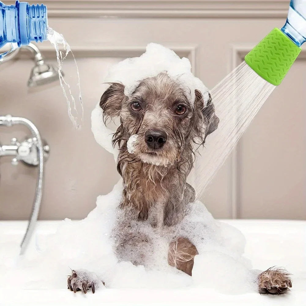 A small dog is being washed with a portable silicone pet shower head in a bathtub filled with soap foam.