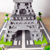 A detailed model of the Eiffel Tower built from gray LEGO-style bricks on a green base.