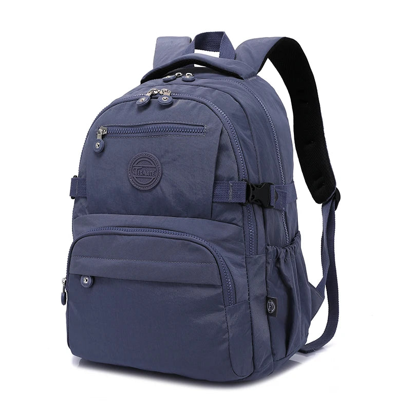 Sac à dos de voyage bleu marine et durable avec plusieurs compartiments zippés et bretelles noires.