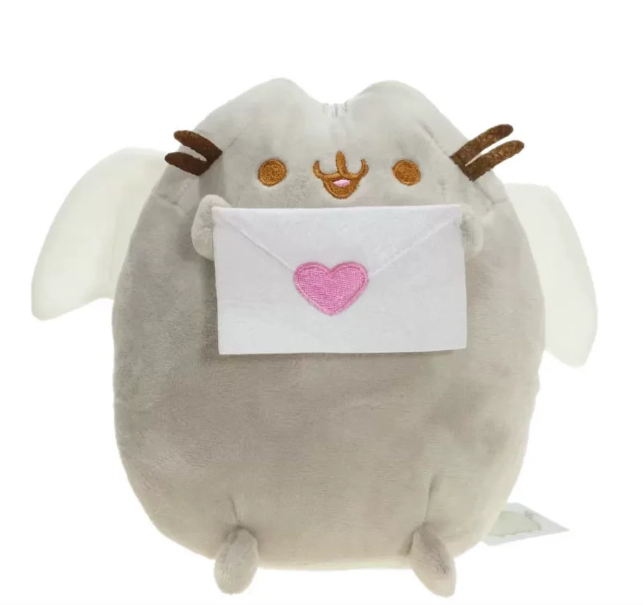 A soft gray plush cat toy with white wings holding a pink envelope.