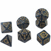 A set of black polyhedral dice featuring gold-colored numbers and symbols for tabletop role-playing games
