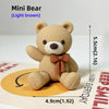 A light brown Mini Bear stuffed toy sitting on a card with measurements.