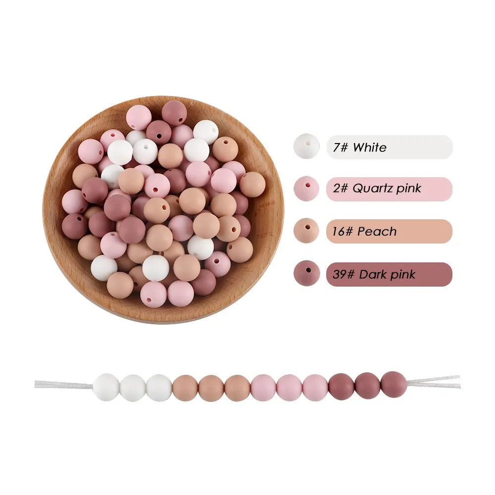A collection of silicone round beads in various shades of pink and white, including quartz pink, peach, and dark pink.